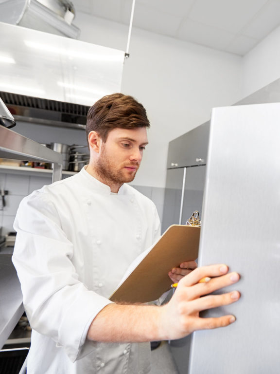 Chef with clip board in kitchen - food service 